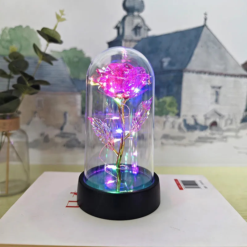 Small plastic night lamp with floral decoration and coloured light options on a black base.