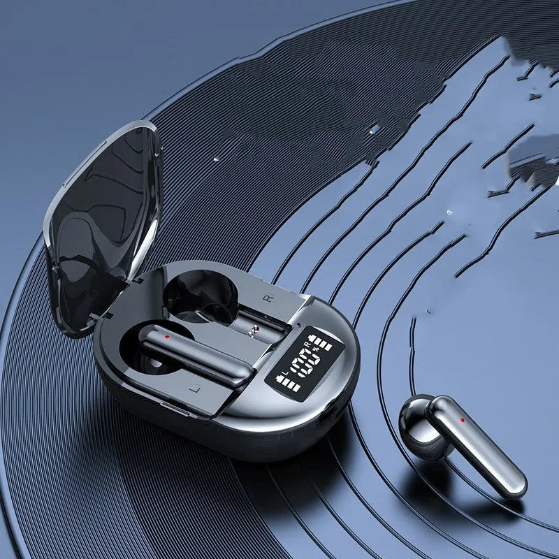 Black and white wireless Bluetooth in-ear headphones with a charging bin on a table.