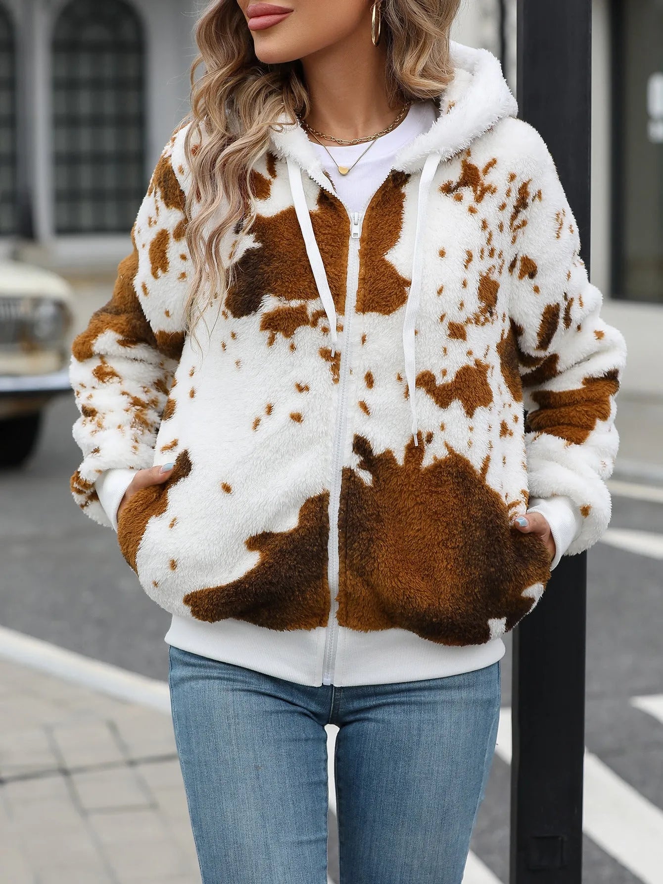 A man's yellow and brown cow print hooded cardigan jacket with a front zipper.