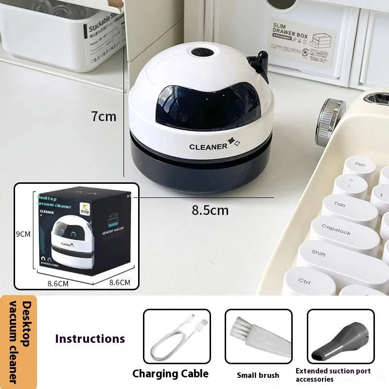 USB charging handheld desktop vacuum cleaner in blue rocket design on computer keyboard