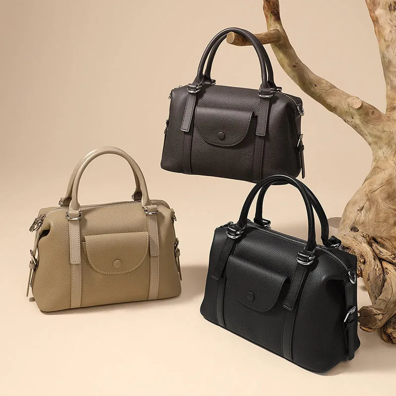 Genuine leather ladies handbag in black, brown, or elephant grey with contrast stitching and a lock.