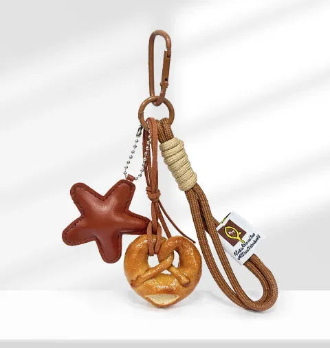 Handmade brown star resin handbag pendant with cartoon soda bread design on a brown strap