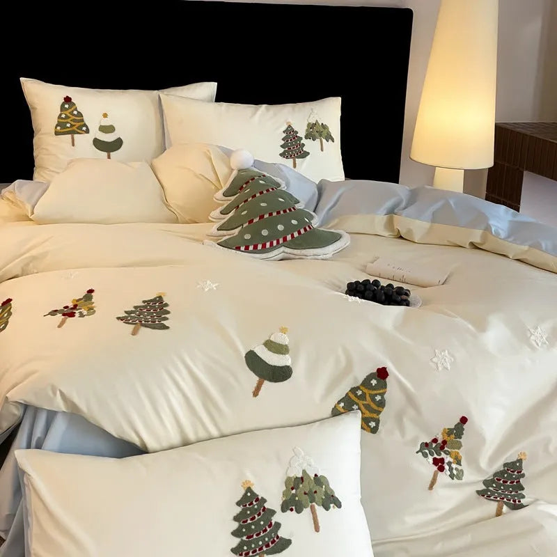 Cream blue Christmas tree embroidered pure cotton duvet cover, flat sheet, and pillowcases on a bed.