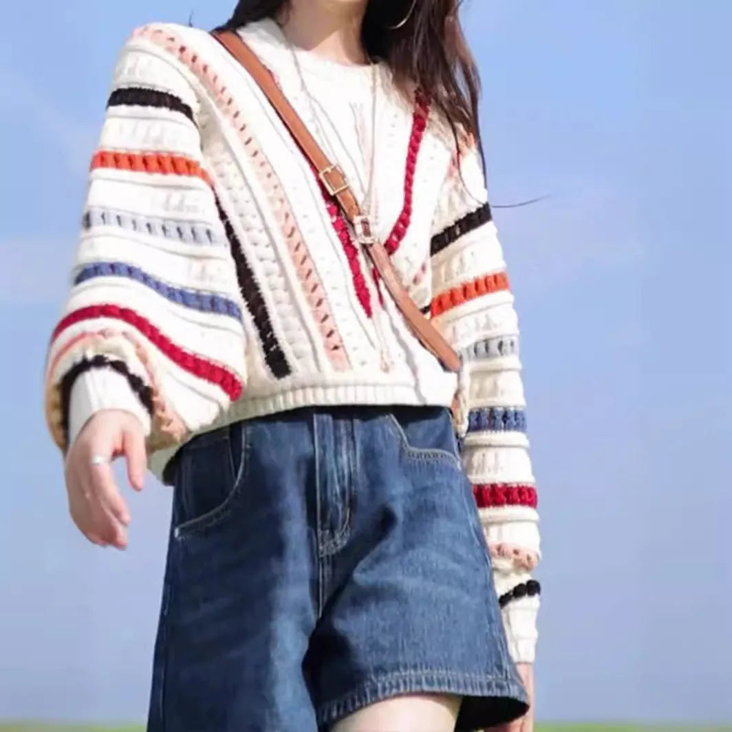 Colourful retro rainbow striped loose sweater with batwing sleeves on a hanger