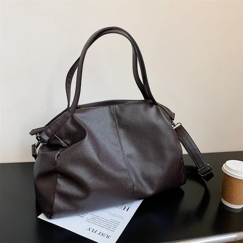 Large soft black PU messenger bag with car suture detail, shown with zip open revealing organiser pockets.