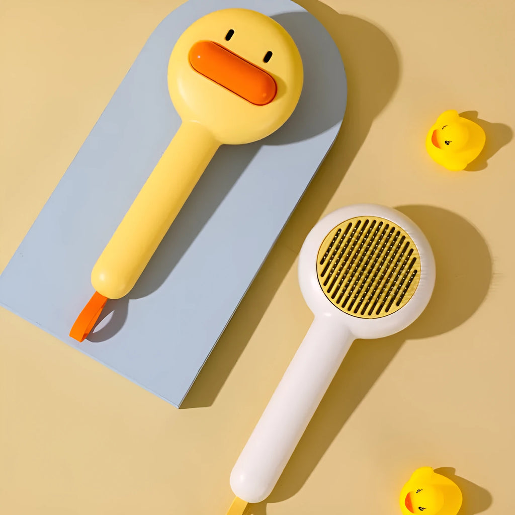 Small yellow duck-shaped pet grooming comb with open section and floating needles