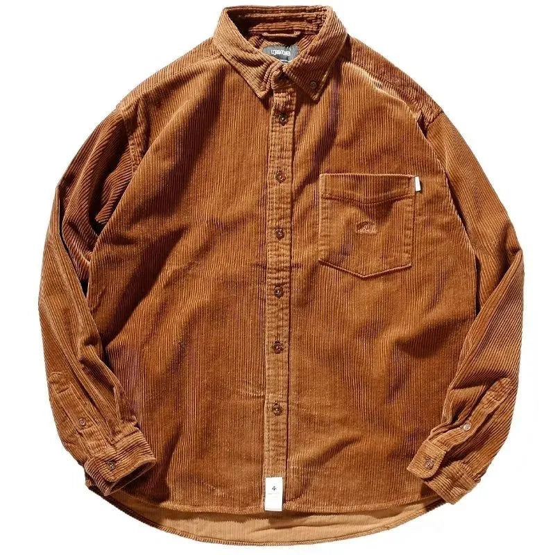 A man wearing a caramel coloured corduroy long sleeve cardigan shirt with a loose fit and button front.