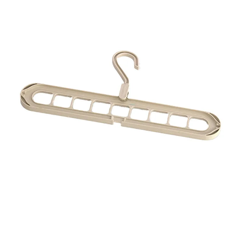 Green plastic multifunctional hanger with nine arms for folding trousers, shown hanging on a rail.
