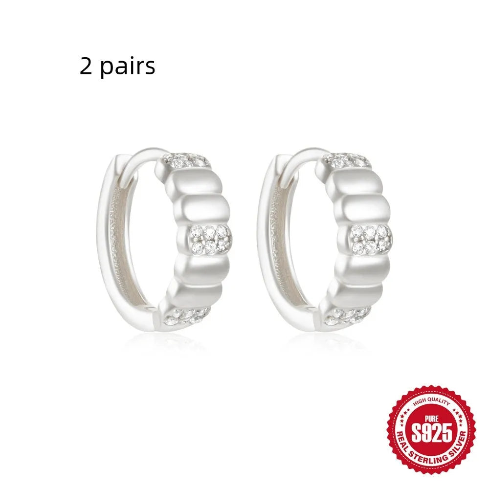 Sterling silver geometric stud earrings with small round diamond detailing in gold and silver electroplated finishes