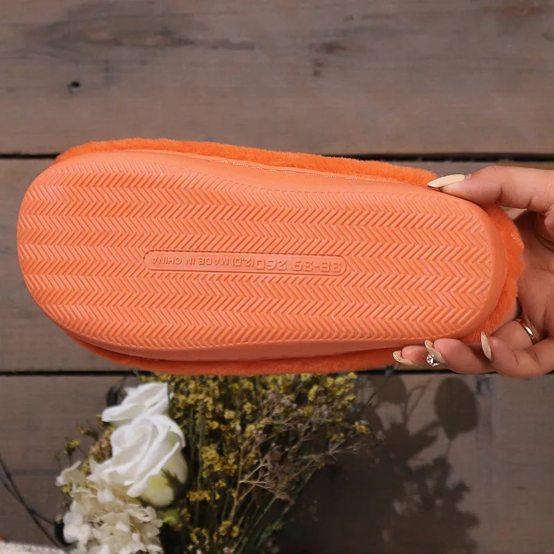 Orange Halloween pumpkin slippers with plush construction and non-slip soles in paired adult sizes