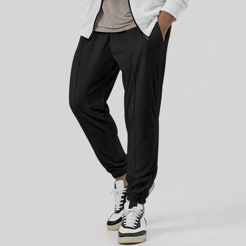 Men's grey casual tapered sweatpants with an elasticated waistband laid flat.