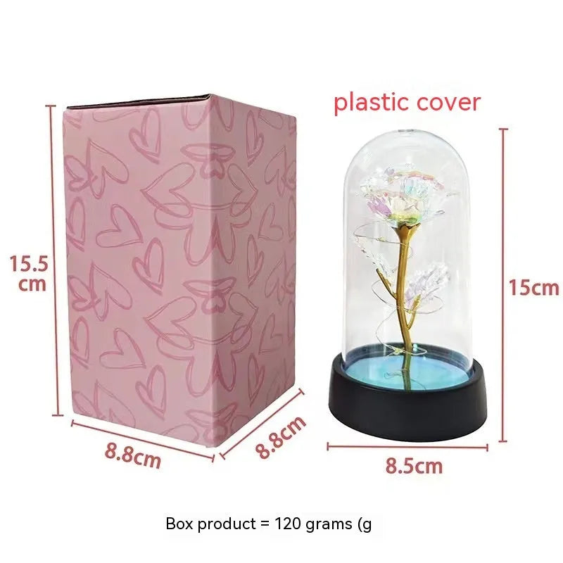 Small plastic night lamp with floral decoration and coloured light options on a black base.