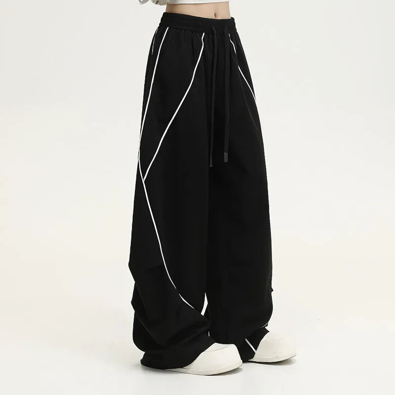 Black pleated hip hop wide-leg pants with stripe pattern showing mid-waist and loose fit