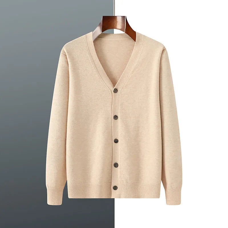 Man wearing a beige V-neck Andy velvet knitted cardigan coat with long sleeves and a loose fit.