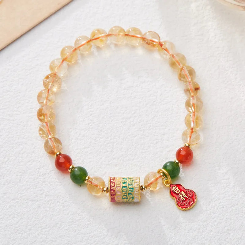 Hand-woven citrine five sutra bracelet with 6mm geometric beads on a wrist.