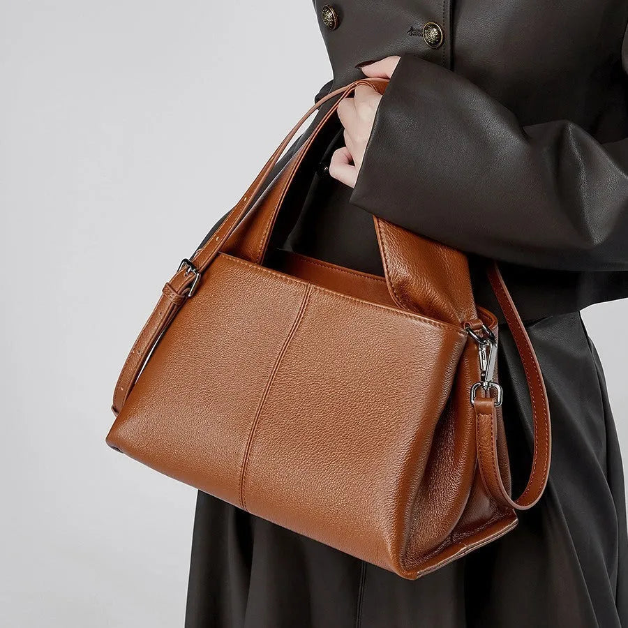Women's genuine leather messenger bag in horizontal square shape with double shoulder strap, shown in apricot colour.