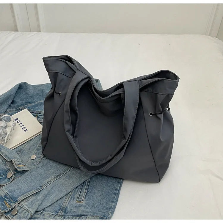 Soft oxford cloth folding commuter tote bag in street style, shown in black, grey, brown, and purple colours.
