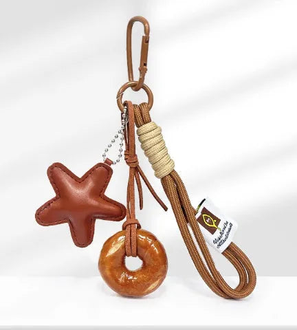 Handmade brown star resin handbag pendant with cartoon soda bread design on a brown strap