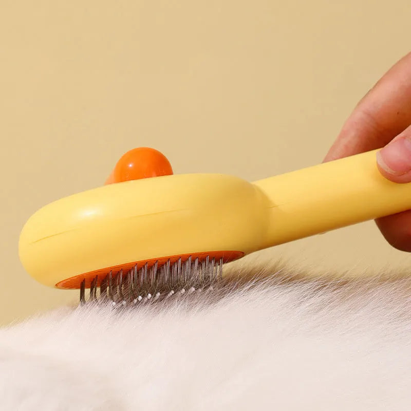 Small yellow duck-shaped pet grooming comb with open section and floating needles