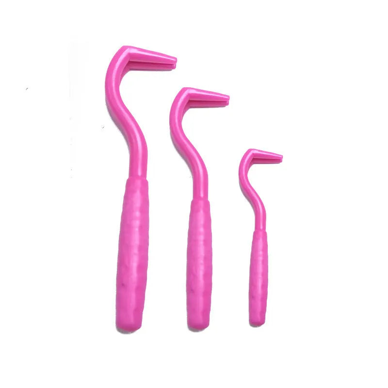 Set of three coloured plastic tick hook removers for dogs on a white background.