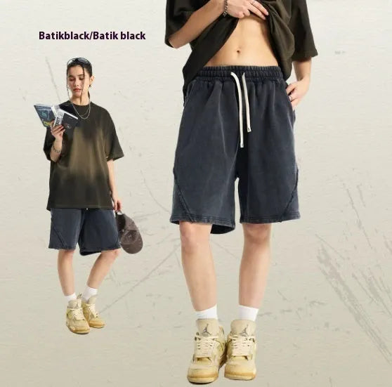 Man wearing loose fit batik-dyed cotton terry shorts in a casual street fashion setting.