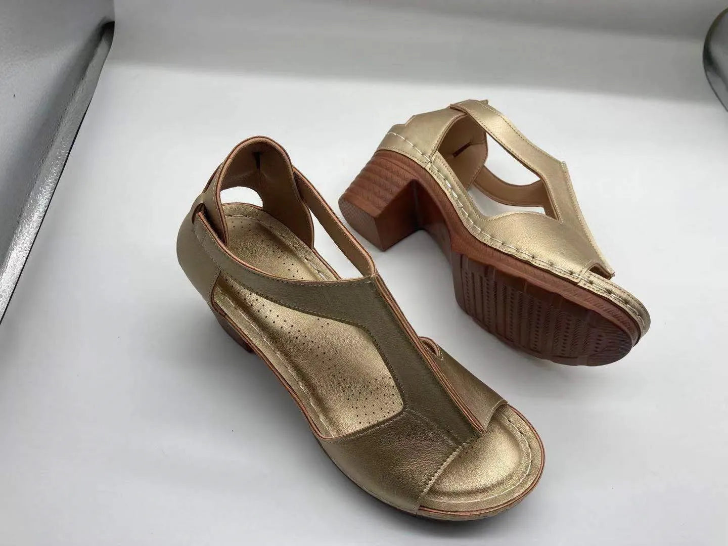 Plus size women's beige open toe wedge sandals with a buckle strap and low heel on a white background.