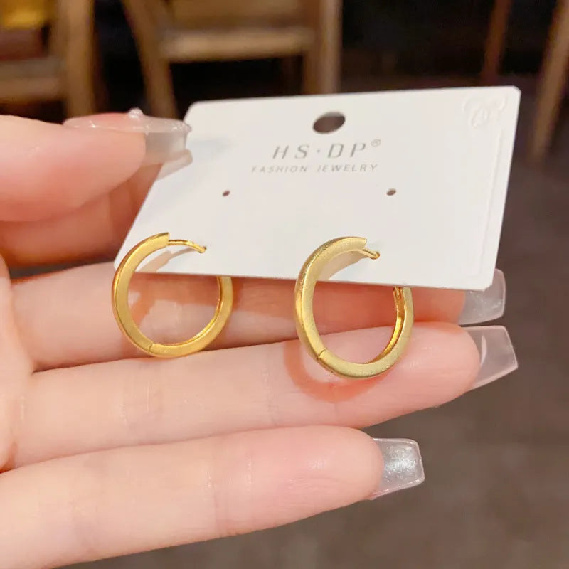 Geometric eyelet ear clips with circular design in gold or silver tone