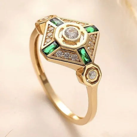 Women's square geometric fashion ring with a green emerald-coloured stone on an electroplated band.