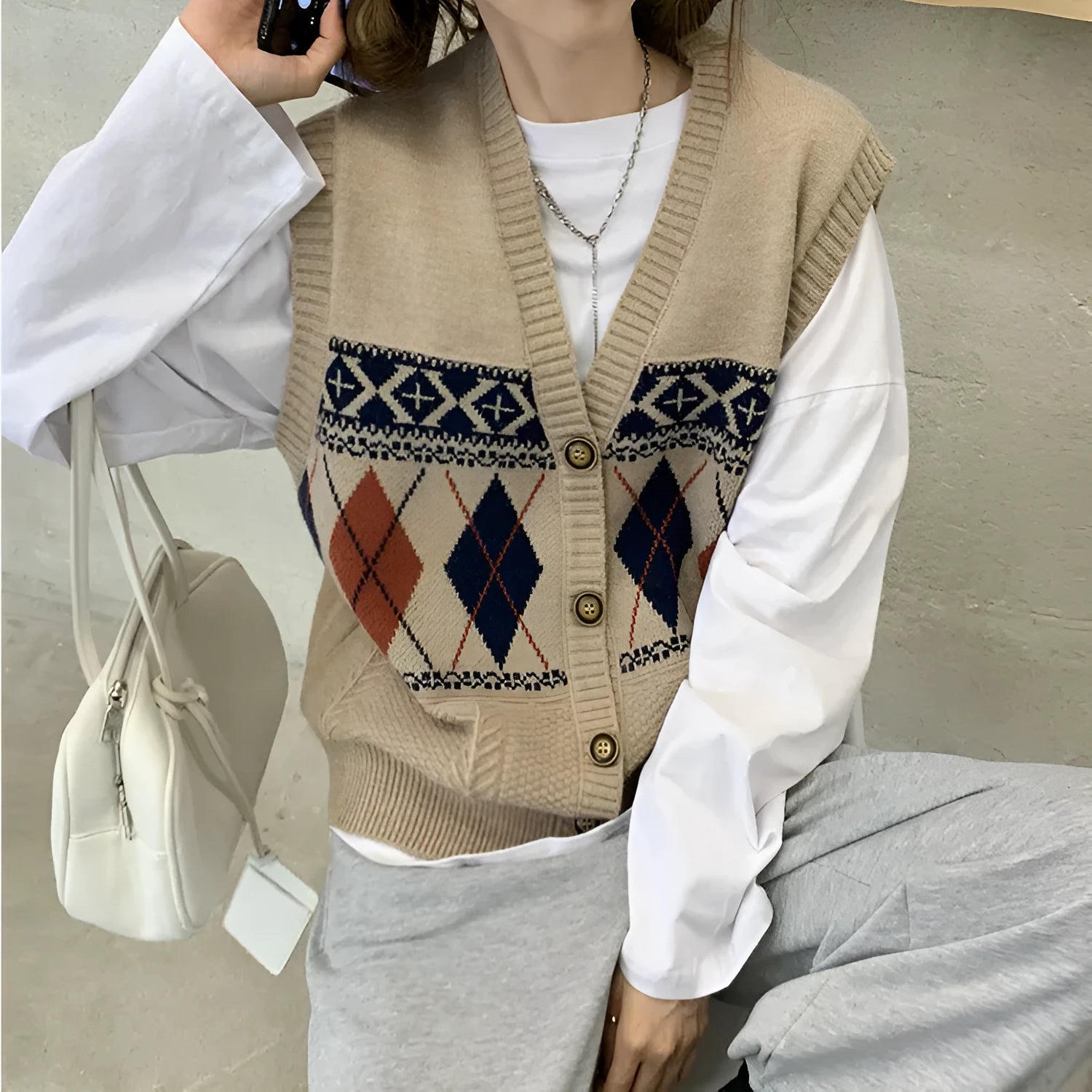Loose-fit sleeveless cardigan with diamond plaid pattern in khaki, shown front view