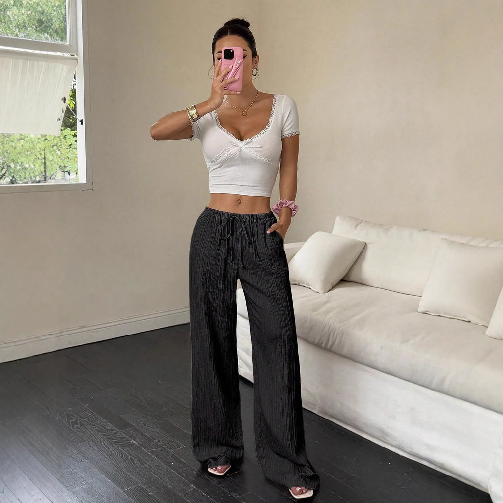 Women's black wide-leg trousers with lace-up waist trimming detail on hanger