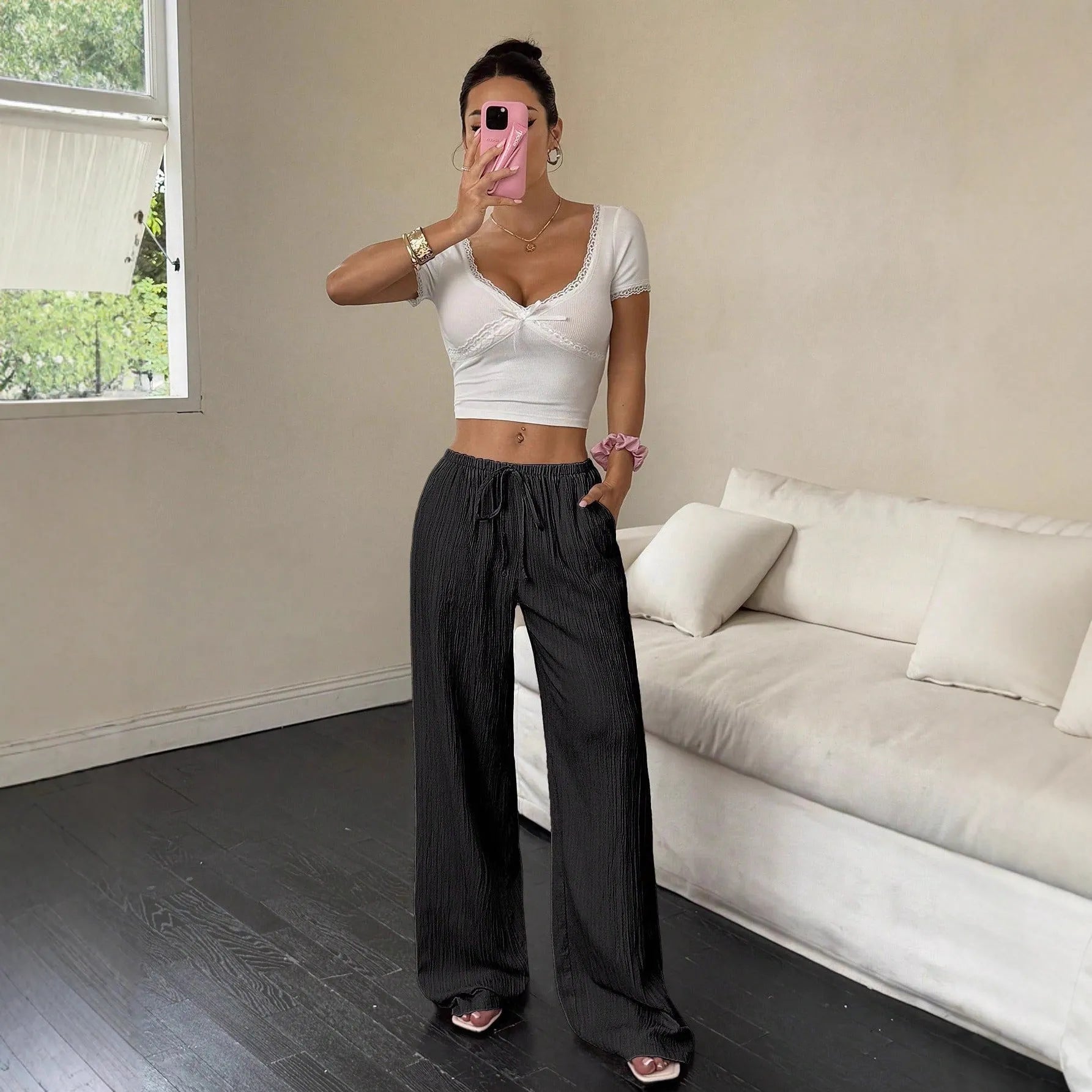 Women's black wide-leg trousers with lace-up waist trimming detail on hanger