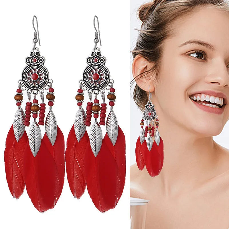 A pair of round drop leaf-shaped feather earrings in a chosen colour, showing Bohemian pattern details.