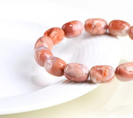 Natural cherry agate barrel bead bracelet with ruyi design elements measuring 10x14mm