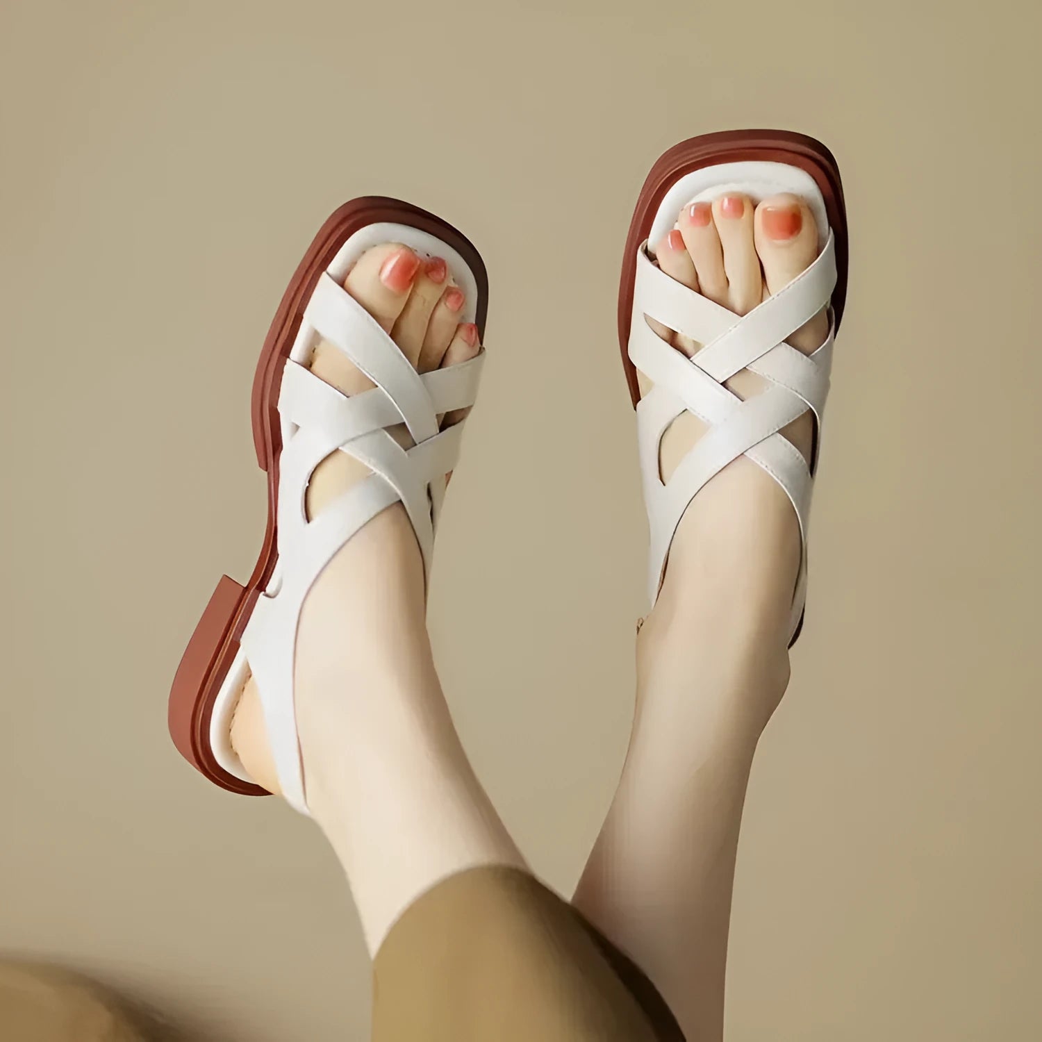 Women's black patent leather square toe sandals with cross straps on a low rubber sole.