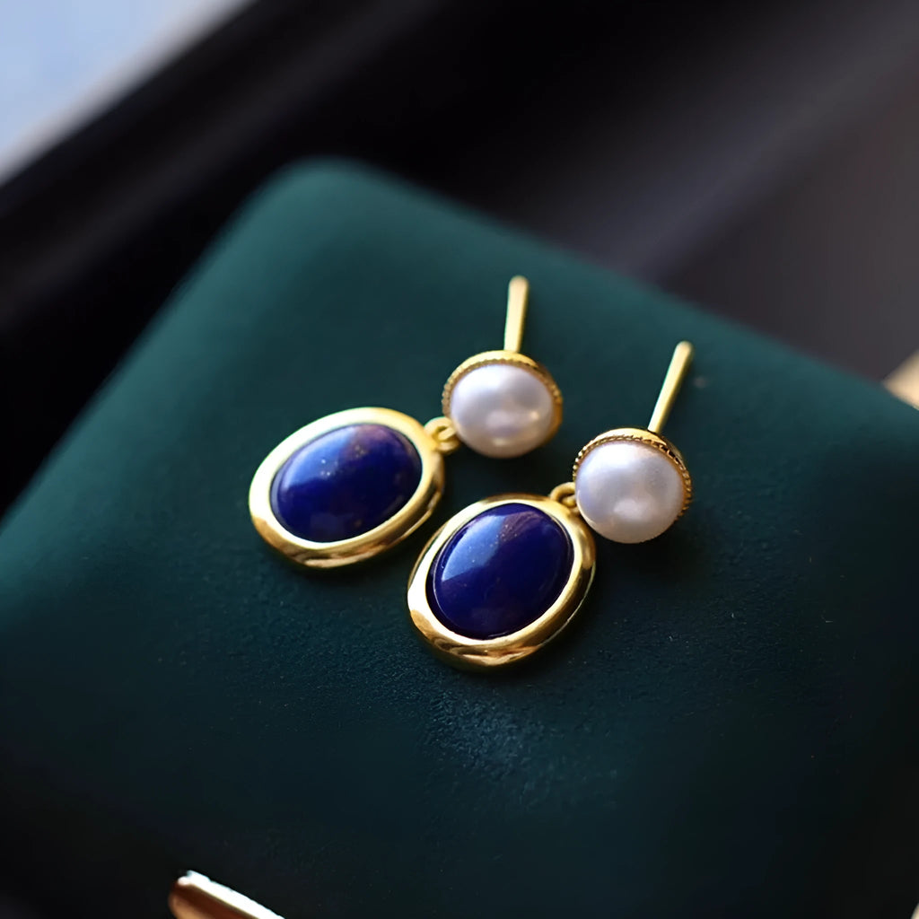 A pair of simple stud earrings with a blue lapis lazuli pearl set in sterling silver.