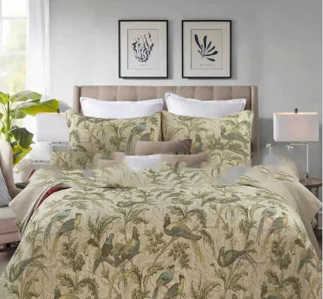 Blue American floral and bird print cotton quilted bedspread set with matching sheet on a bed.