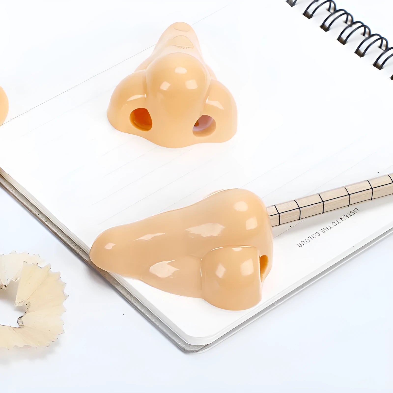 Flesh coloured plastic pencil sharpener with big nostril hole showing compact geometry shape
