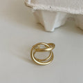 Geometric open ring for women with 3D interlaced matte metal design in gold or silver.