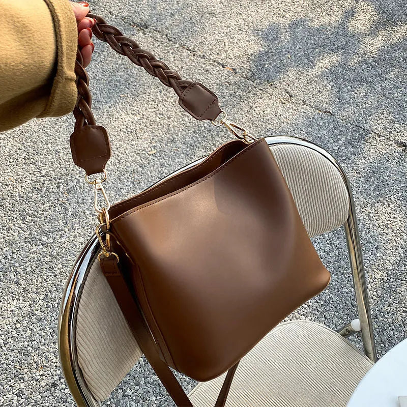 Retro khaki crossbody bucket bag with woven PU detailing and adjustable strap.