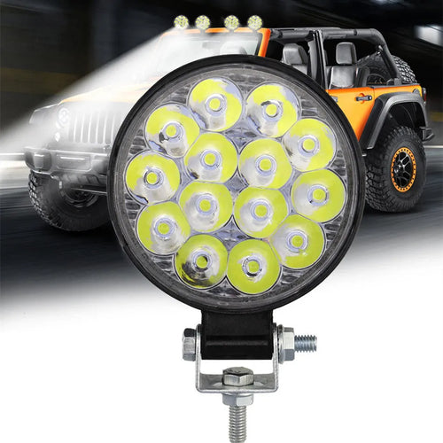 Mini round 42W LED work light with aluminium housing, emitting white light for vehicle use.