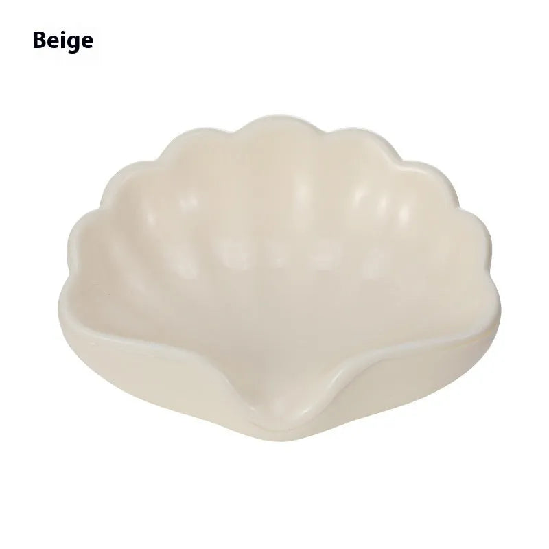 White shell-shaped plastic soap dish on a bathroom countertop.