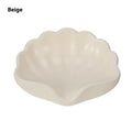 White shell-shaped plastic soap dish on a bathroom countertop.