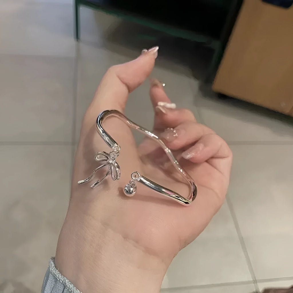 Silver adjustable bracelet with bow charm and sliding clasp mechanism