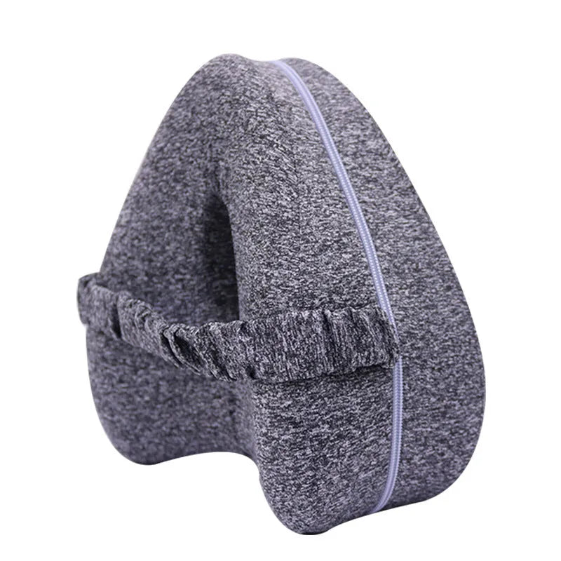 Love heart-shaped dark blue memory foam leg pillow for adults on a bed.