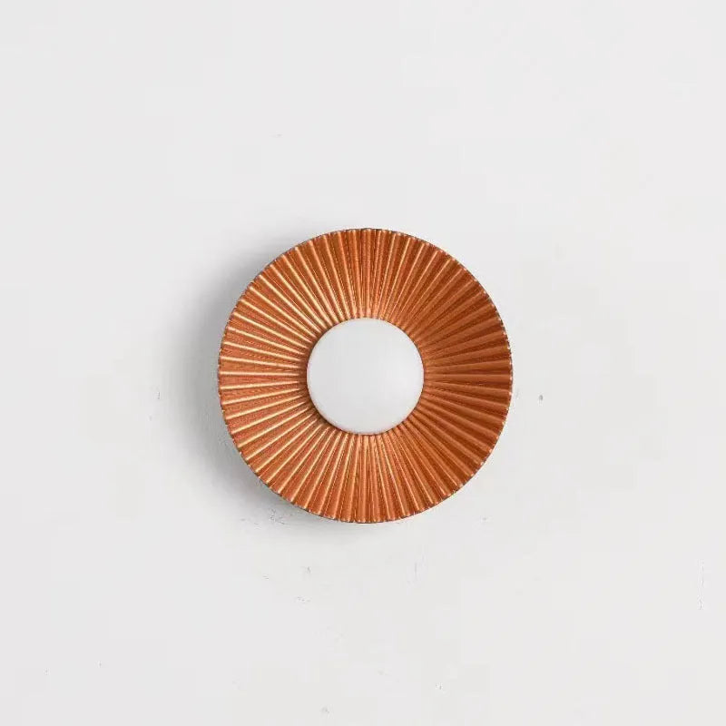 Round aluminium wall lamp with outer white and inner gold finish mounted on a wall