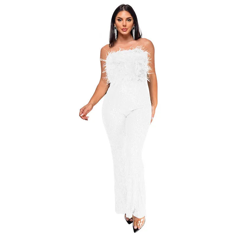 Woman wearing a black sleeveless backless jumpsuit with sequined top and flared legs.