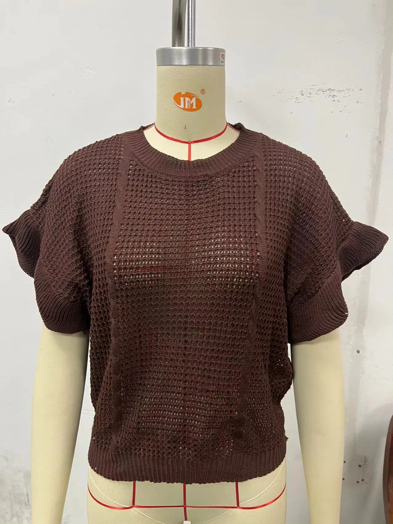 Loose white knitted pullover sweater with detailed twisted string ruffled short sleeves, round neck.