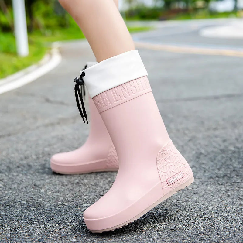 Women's solid colour PVC rain boots with non-slip sole in apricot, black, brown, or pink.