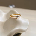 Golden electroplated stainless steel love heart ring and oval ring for women on a plain background.