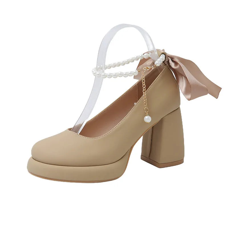 Women's beige Mary Jane shoes with chunky heel, round toe, and ankle strap with pearl buckle.